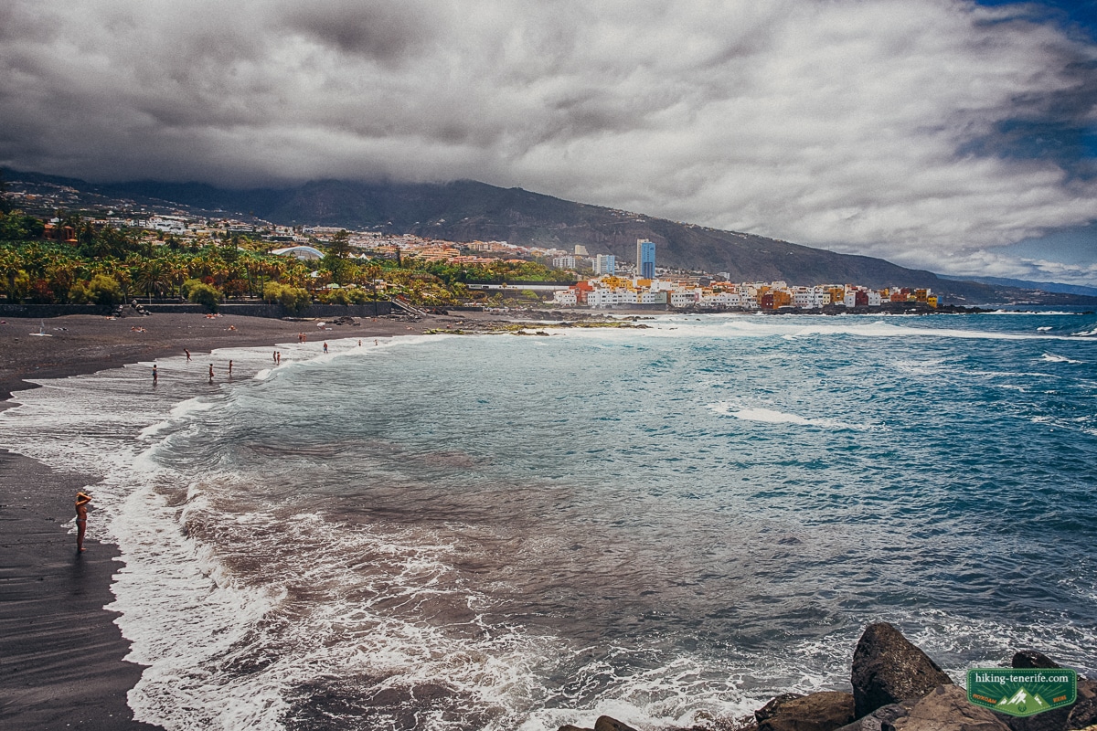 Playa Jardin black sand beach in Puerto de la Cruz with cloudy mountains