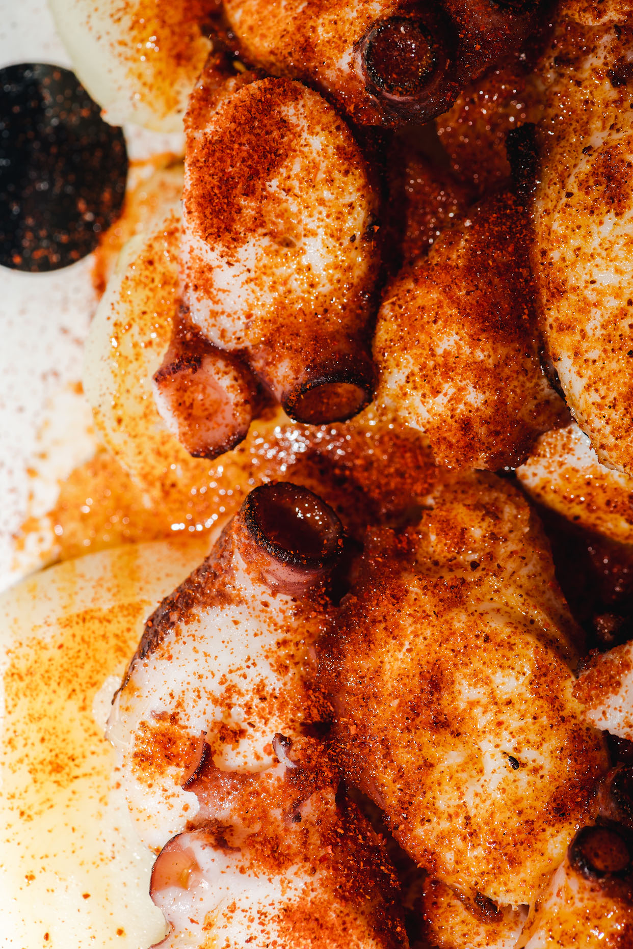 Tender cooked octopus pieces coated with olive oil and smoked paprika