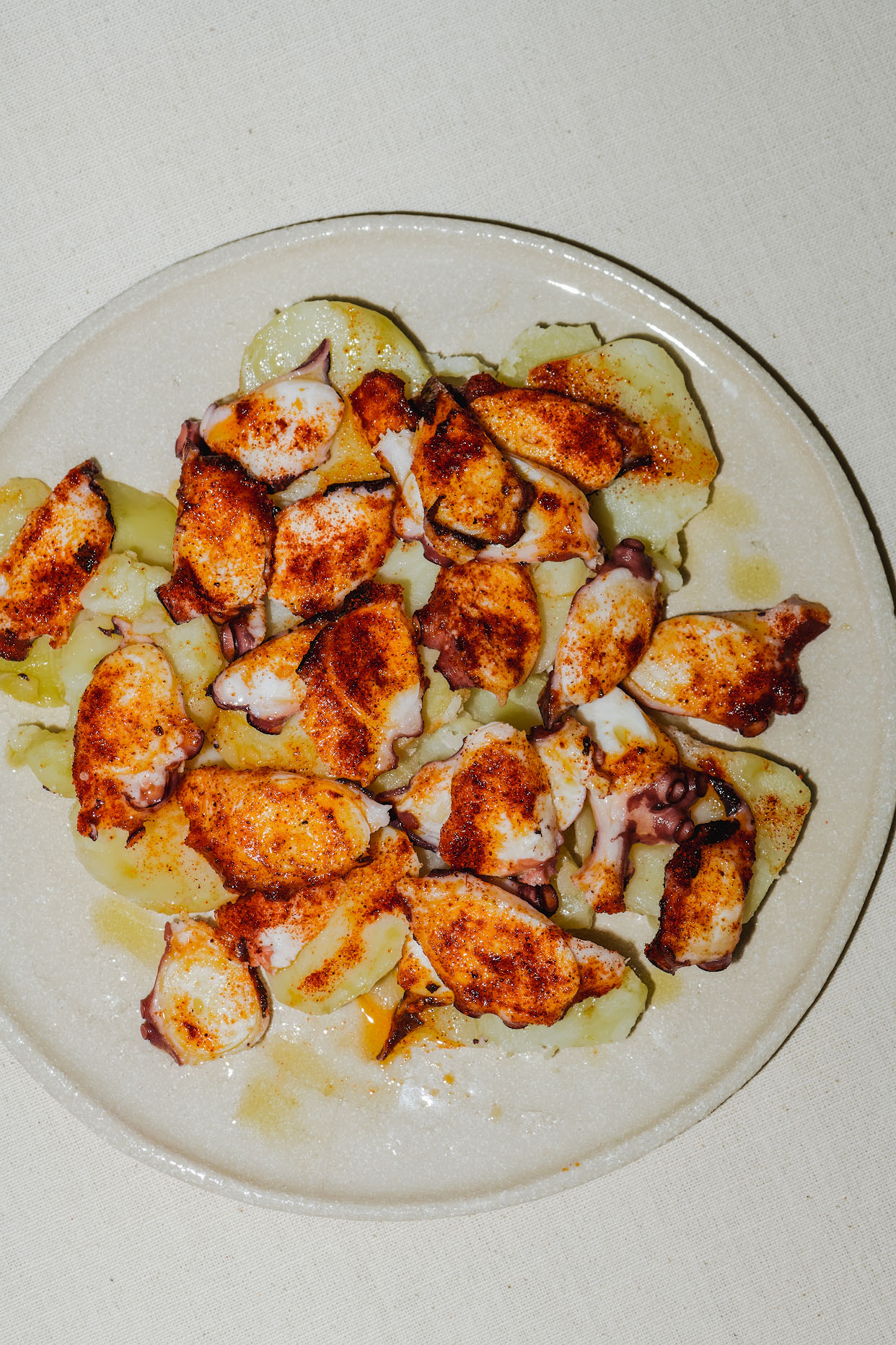 Grilled octopus pieces finished with olive oil and paprika