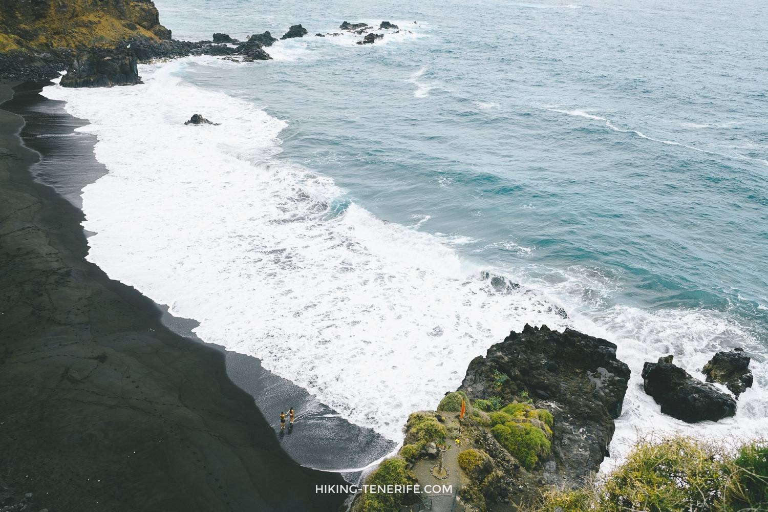 Wild black sand beach in Tenerife with waves and rocks