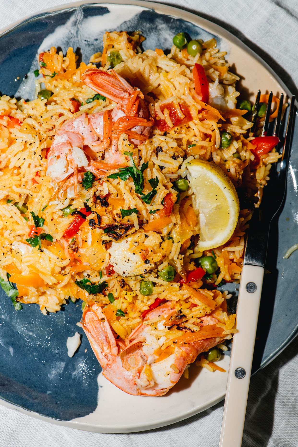 Serving of Tenerife seafood paella with prawn white fish lemon and parsley