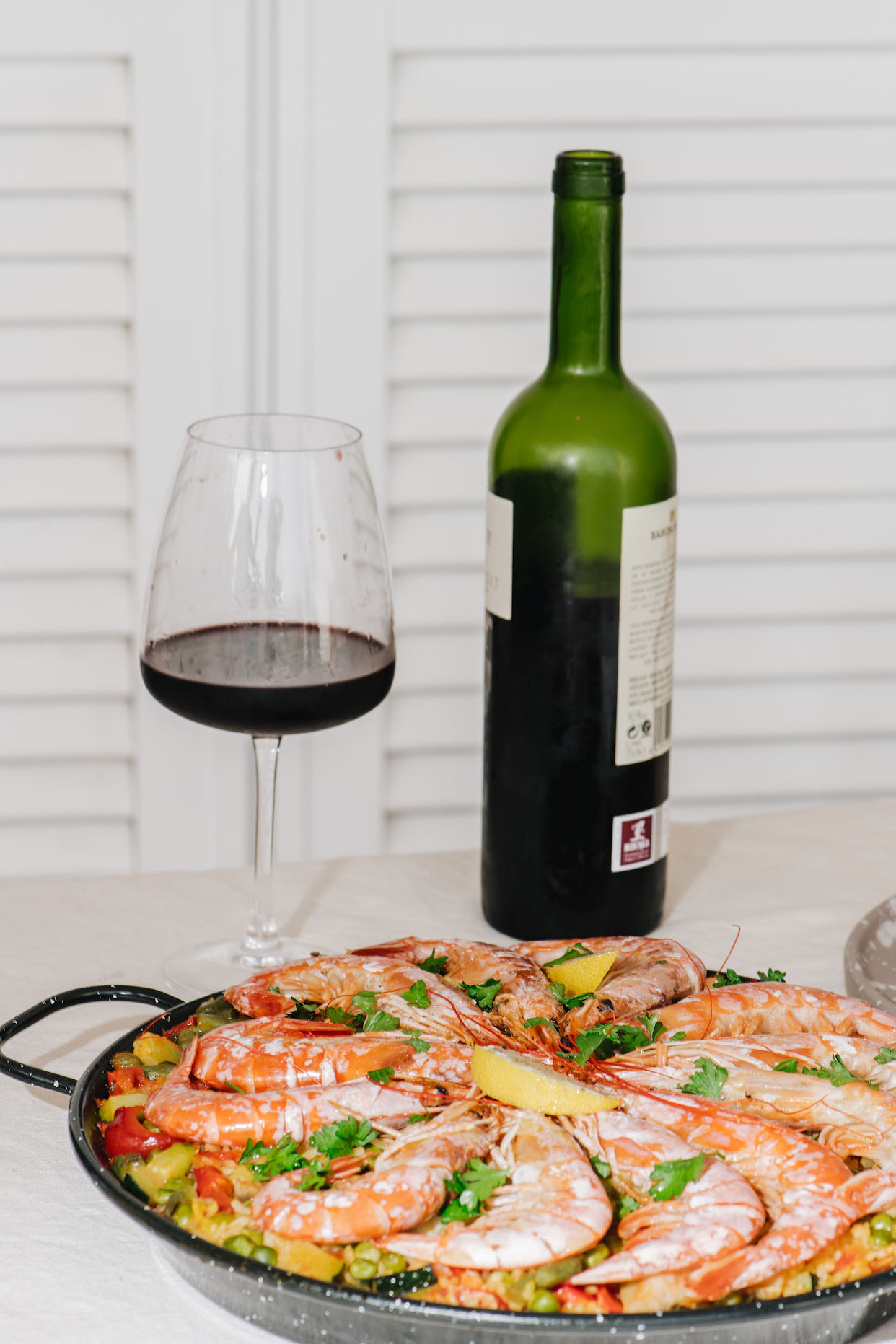 Seafood paella pan on a Tenerife dinner table with red wine