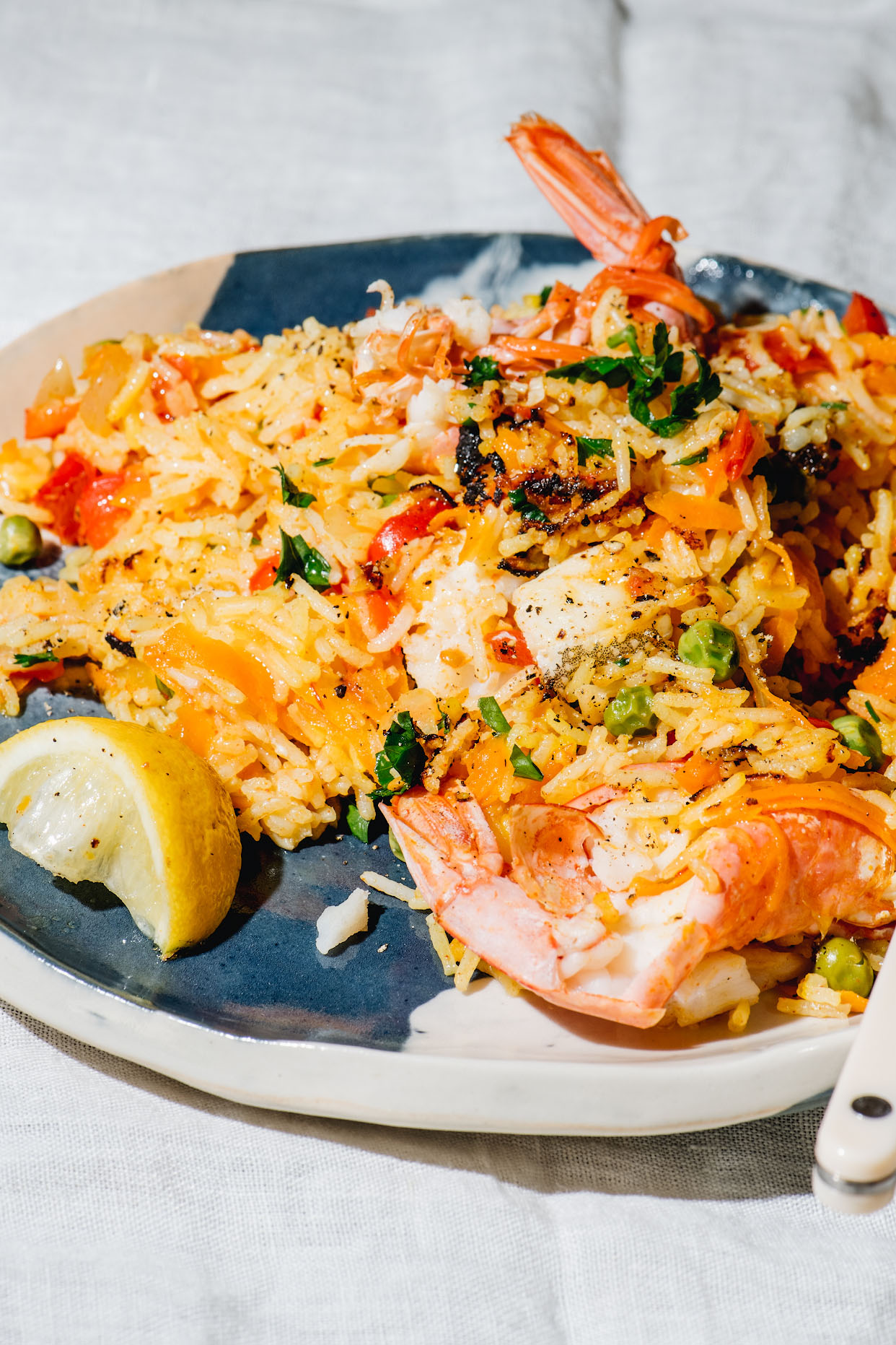 Seafood paella portion with prawn lemon crisped rice and parsley